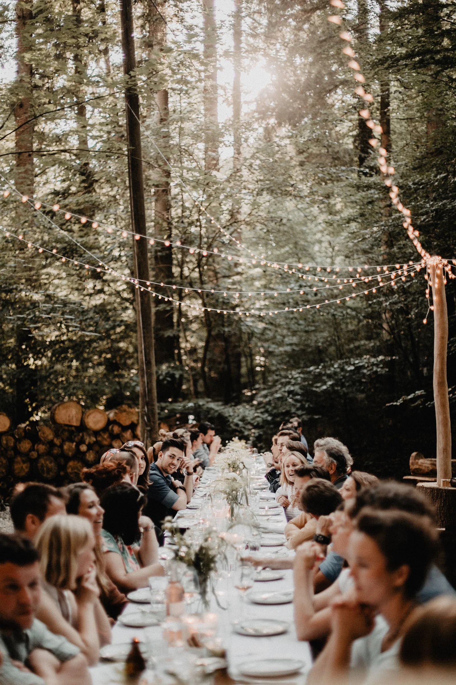 Rein ins Grün — lange Tafel im Wald mit Lichterketten und Team bei Projekt Draussen